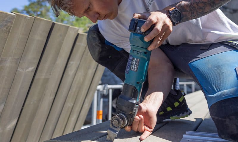 mann jobber på ny terrasse med elverktøy