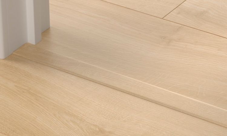 Lys eikegulv med terskel og hvit dørkarm.