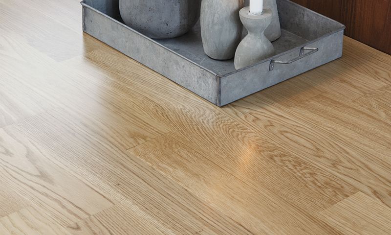 Galvanisert metallbrett med grå sementvaser og hvitt stearinlys på lyst eikebord.