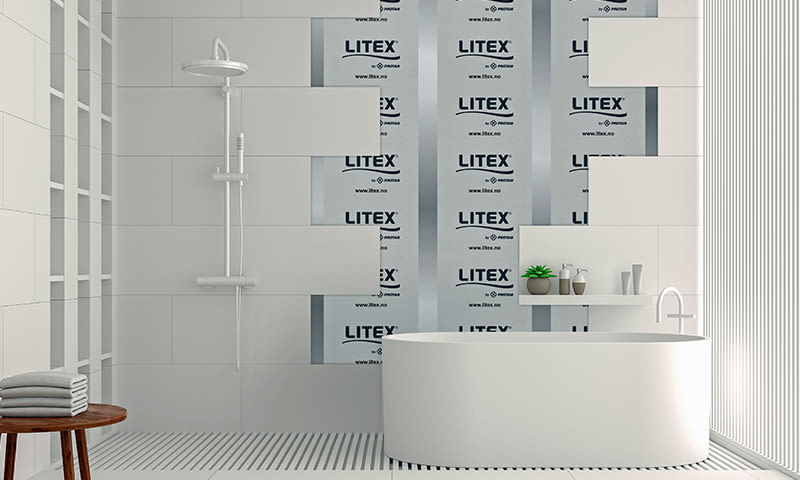 Moderne hvitt bad med frittstående badekar, dusj, krakk med håndklær og LITEX-isolasjon