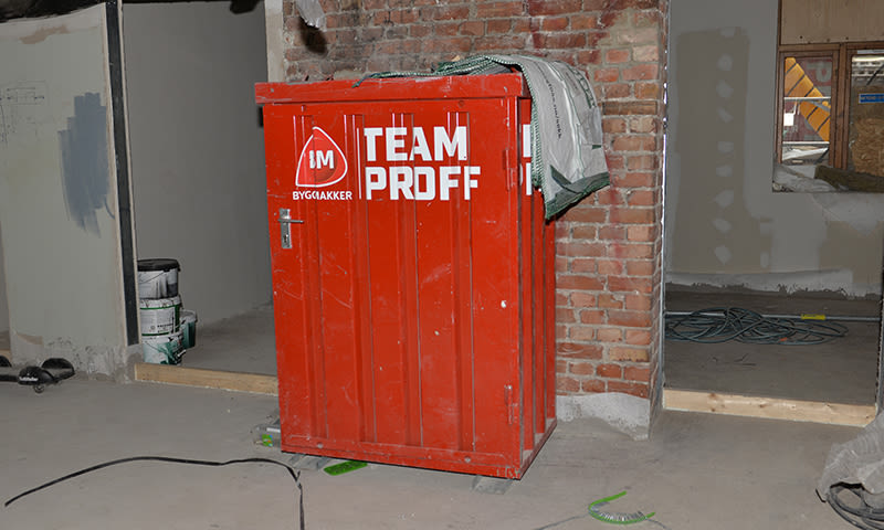 Rødt Team Proff-verktøyskap foran uferdig murvegg på byggeplass.