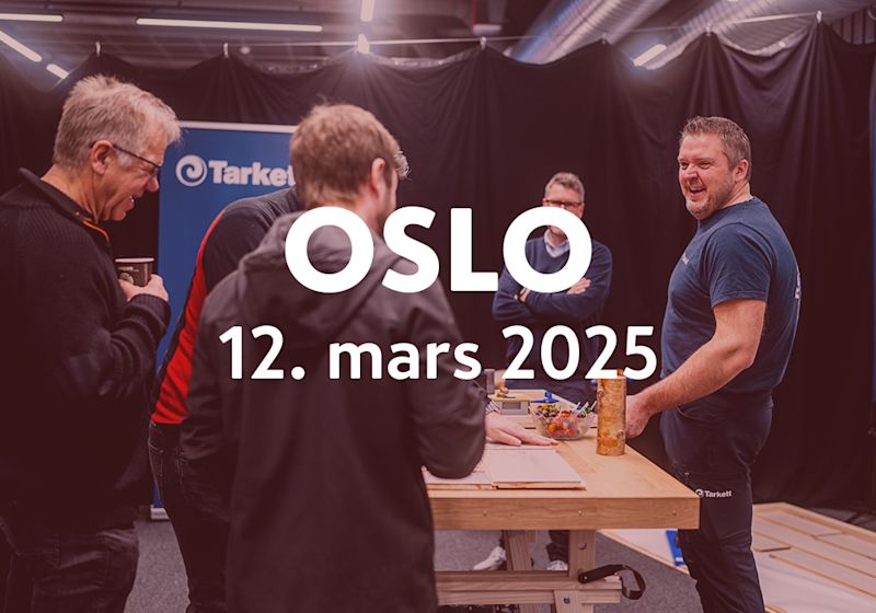 Gruppe menn rundt lyst trebord med gulvprøver, godteriskål og blå Tarkett-plakat bak.