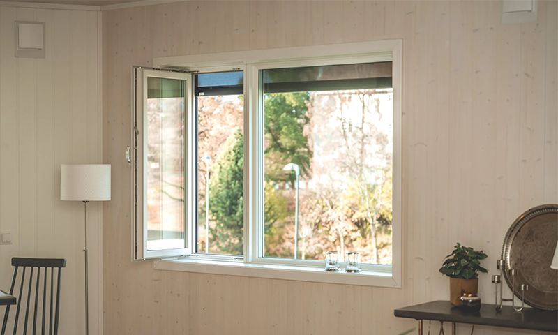 innadslående vindu på lys trevegg innendørs