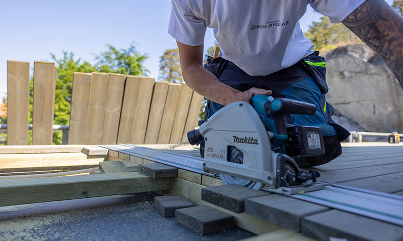 mann bruker elverktøy fra makita for å bygge terrasse