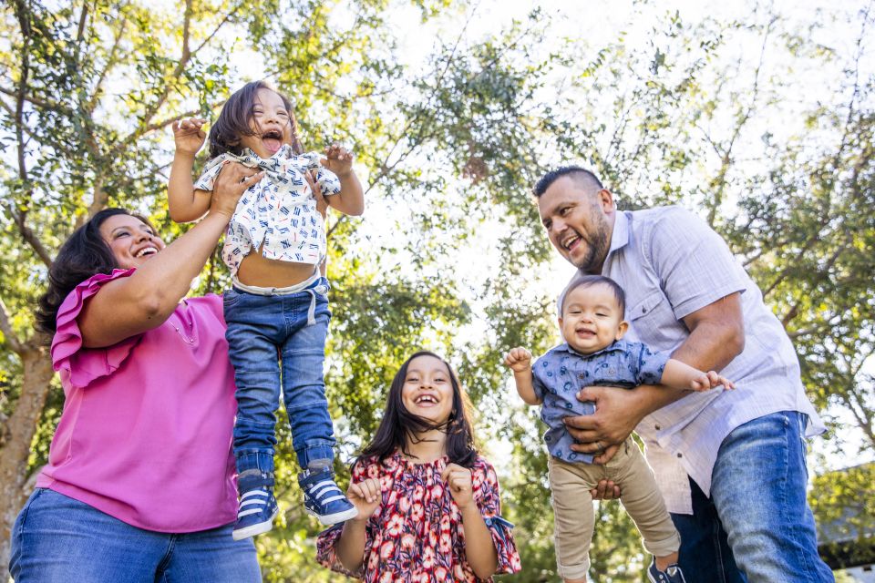 Familia con tres niños se ríen en el parque