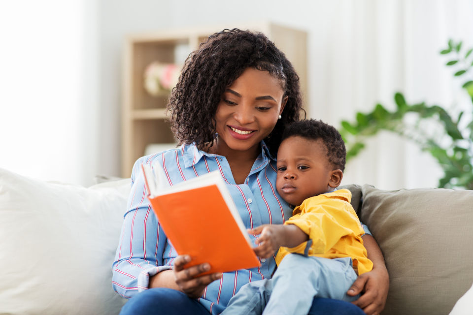 Mother reading to boy on couch