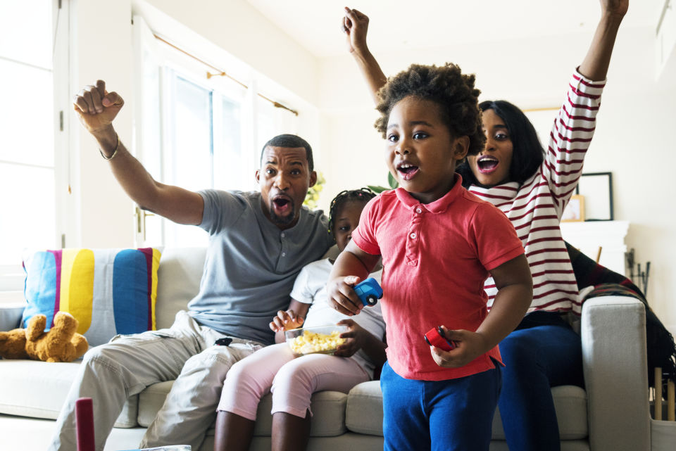 Family Cheering on watching TV in living room