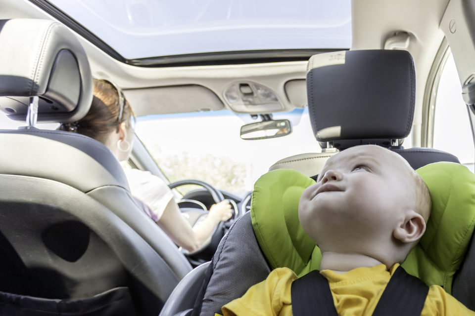 Bebé sentado en el asiento para niños en la parte de atrás del automóvil