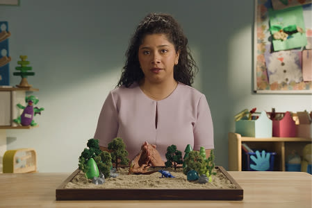 A woman standing in front a childs toy. A woman standing in front a childs toy.