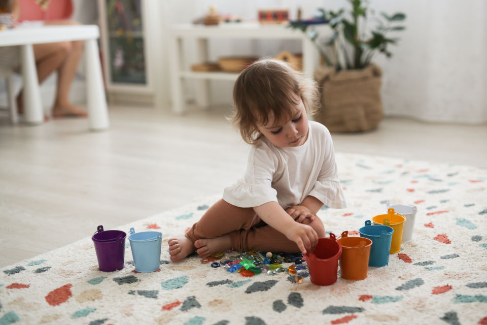 Girl on floor playing with toys
