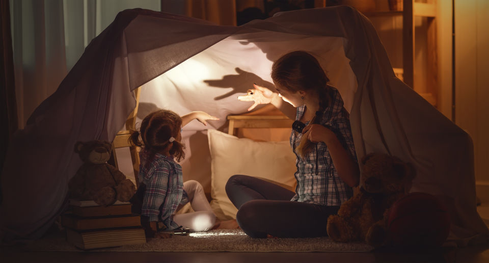 Mom and daughter in fort making hand shadows