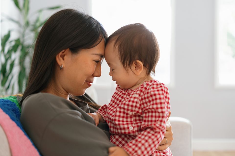 Mother holding her baby and smiling Mother holding her baby and smiling