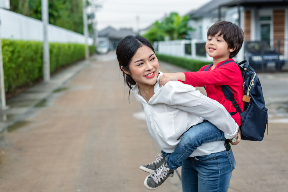 Mother giving son a piggy back ride