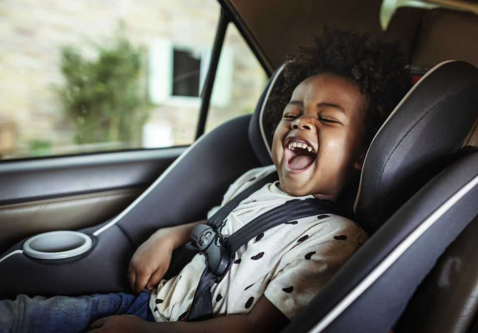 Toddler-Boy laughing in car seat 