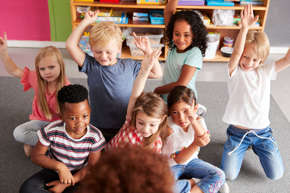 7 Students in class excited raising hands