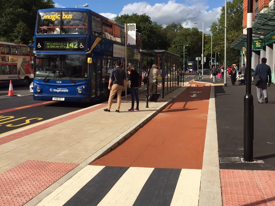 An image showing a bus stop bypass with passengers waiting to get on a bus