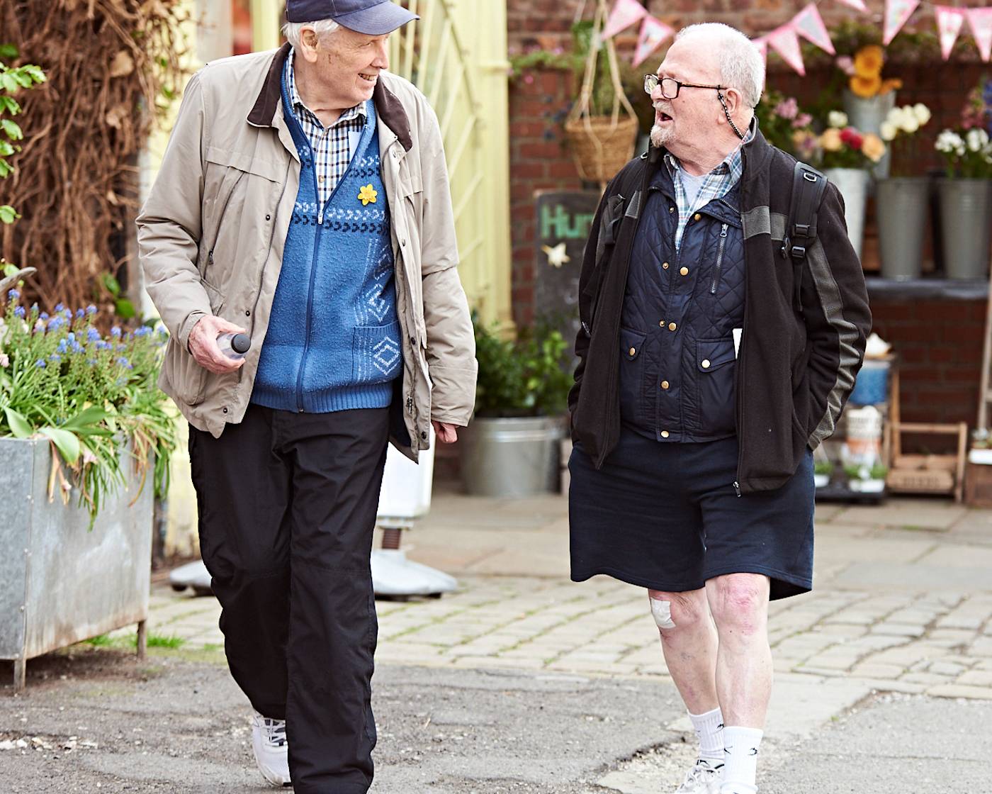Two older men walking along a pedestrianised street