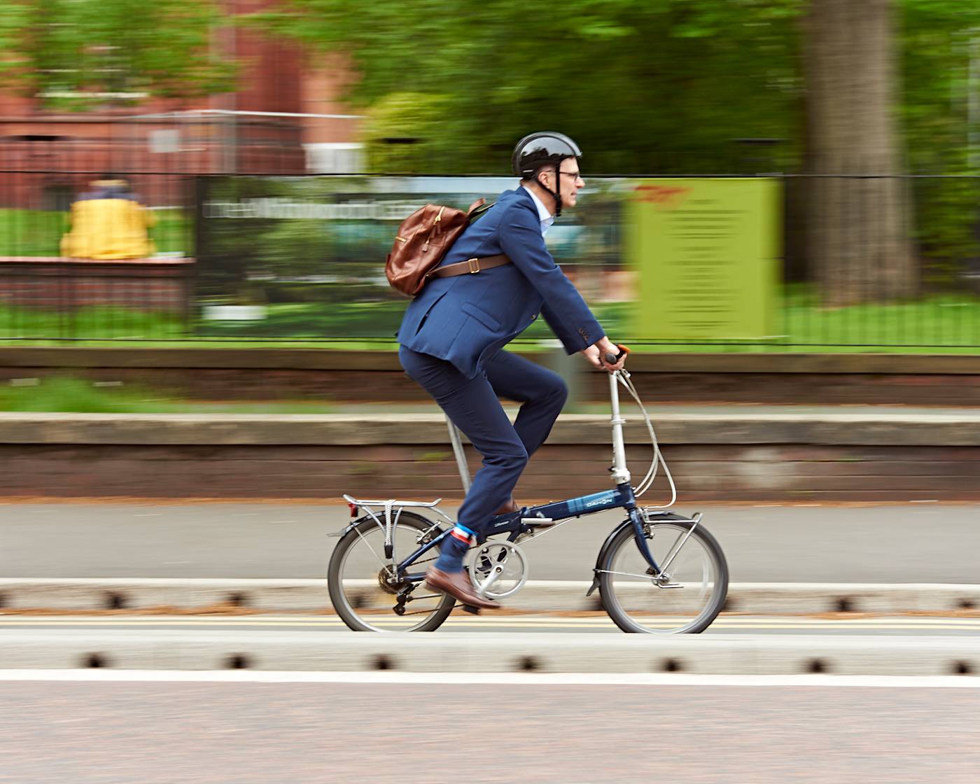 A man cycling along a protected cycle lane