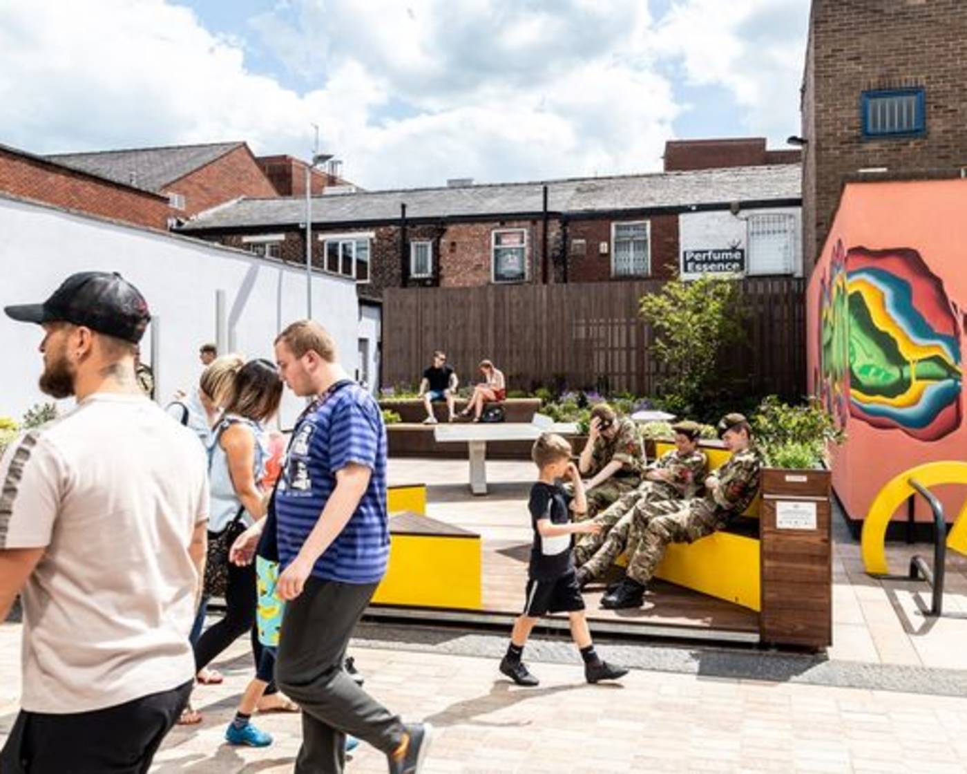 A Parklet in Stockport with adults and children walking around