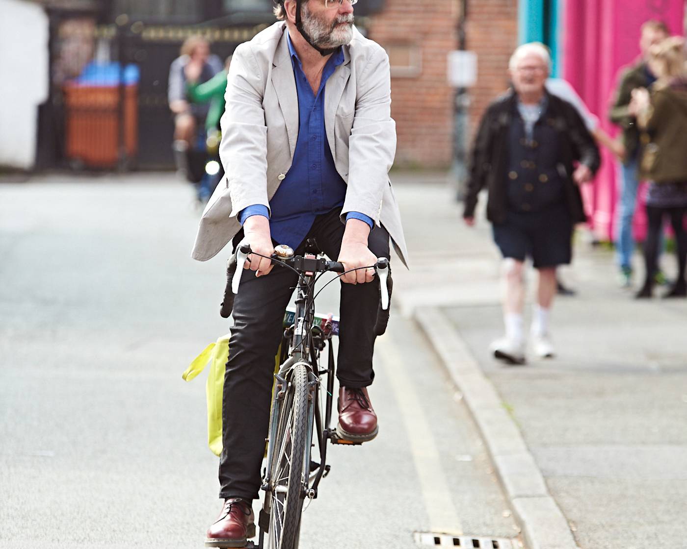 Cycling - middle aged gentleman with helmet riding down a side street