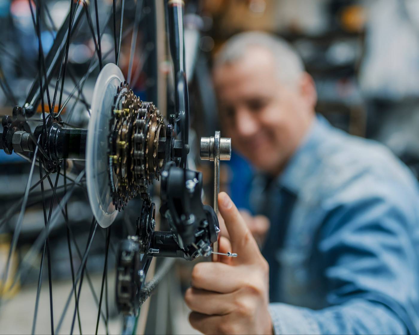 Close up of bike gears being tweaked by bike repair person