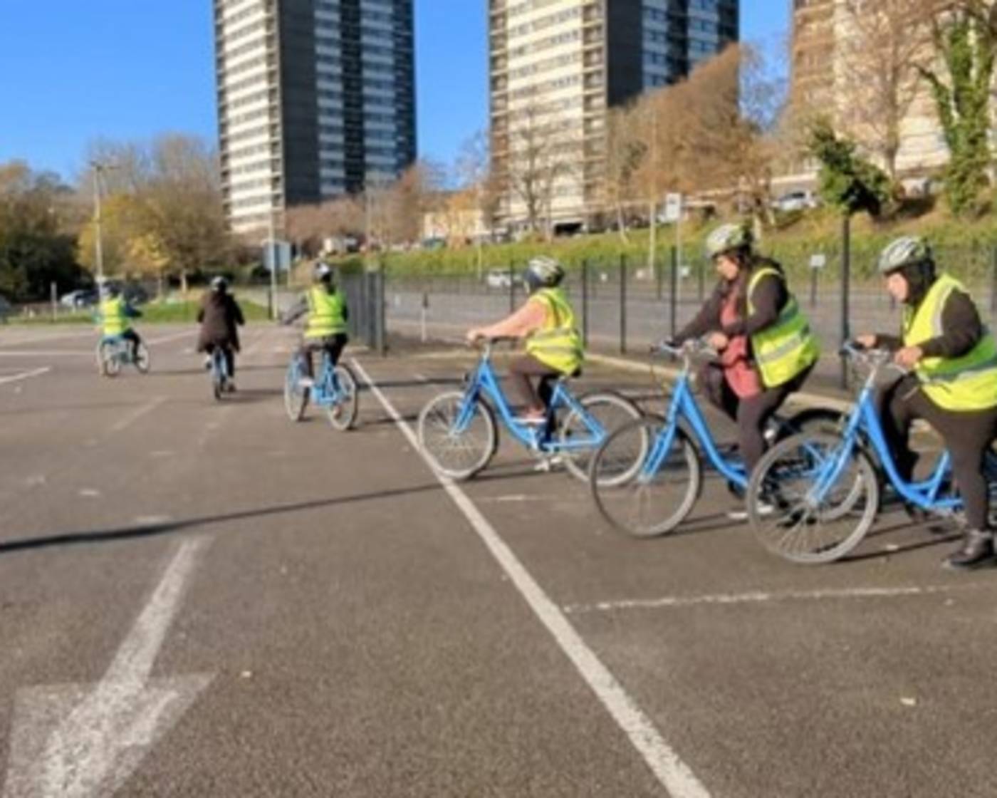 Group of people wearing high viz taking part in a cycling lesson