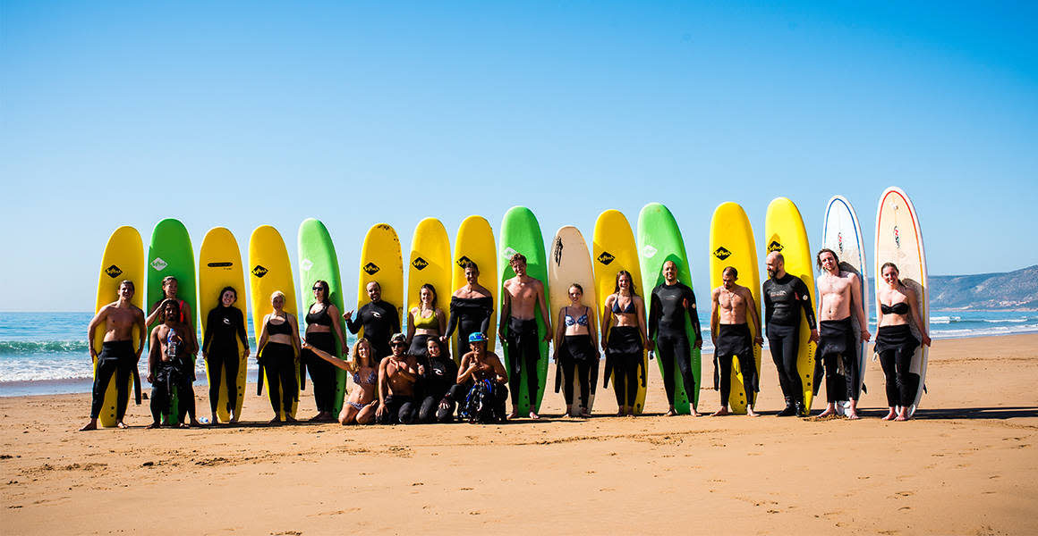 surfers holding foamboards at the beach