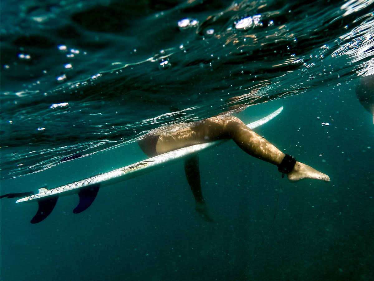 Underwater shot of surfer sitting on surfboard