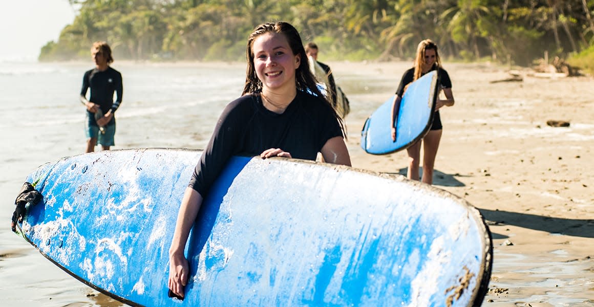 girls holding surfboards at the beach