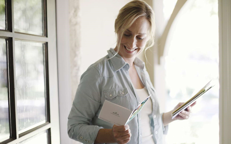 Woman Reading Greeting Card in Doorway ARTICLE HERO IMAGE