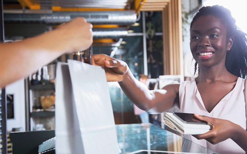 Employee Handing Customer Shopping Bag ARTICLE HERO IMAGE