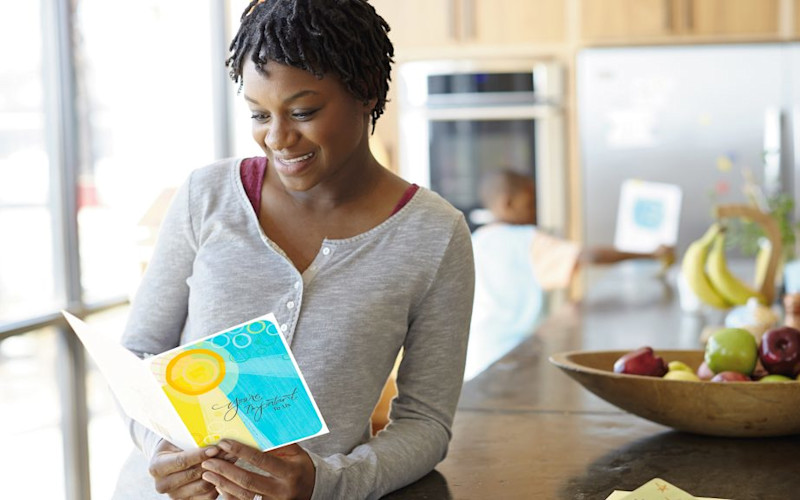 L female reading youre important to us card in kitchen