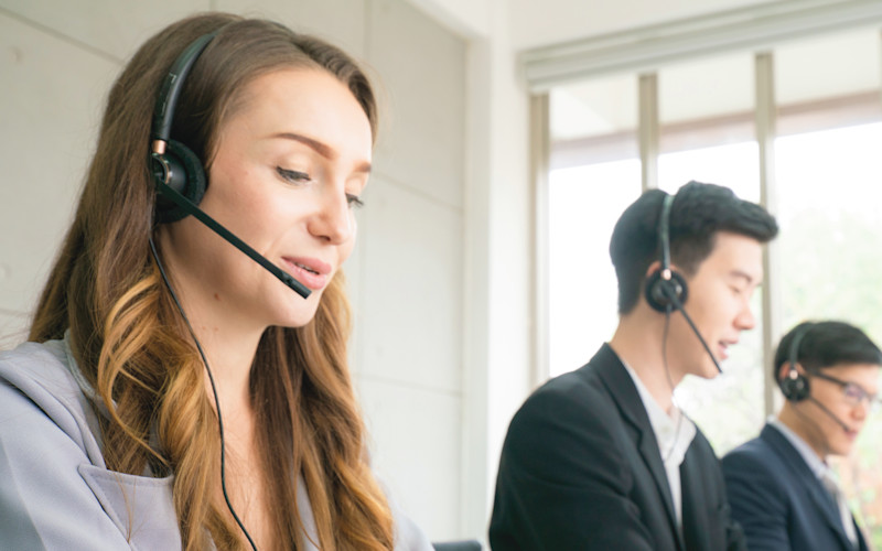 Article Hero | CX Lifestyle - 3 reps with headphones at computers