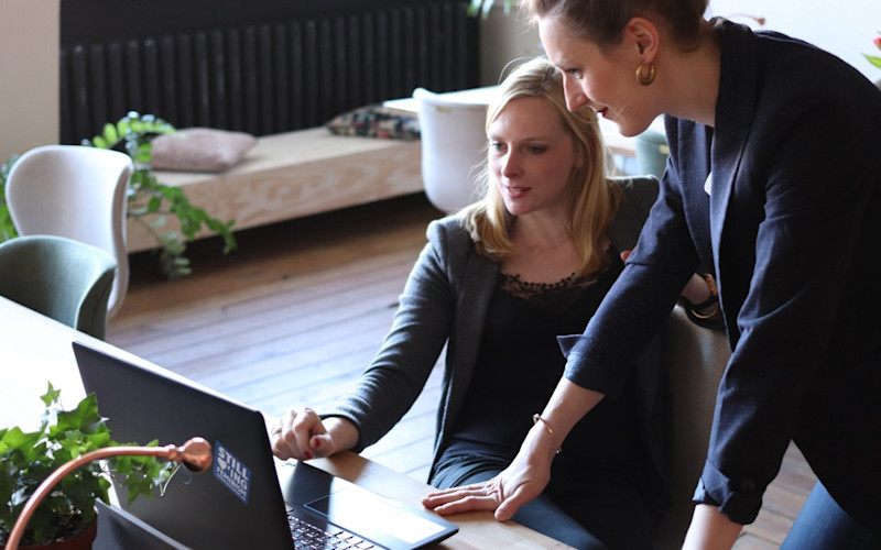 2 Women Coworkers Looking at Laptop