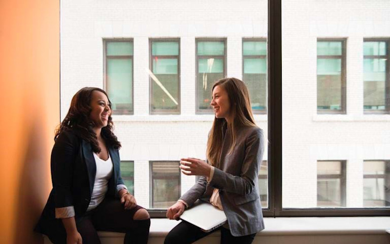 Women Talking in Window ARTICLE HERO IMAGE