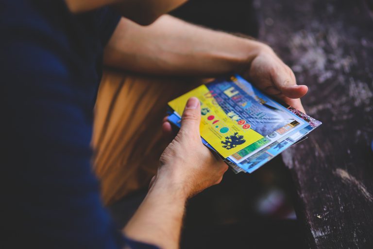 Man holding postcards in urban setting