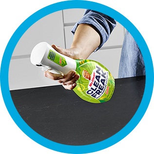 A person cleaning a kitchen countertop with CleanFreak Gain