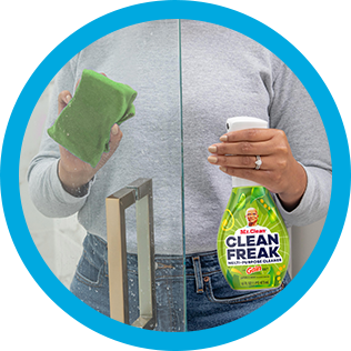 A person cleaning soup scum of shower glass with CleanFreak Gain