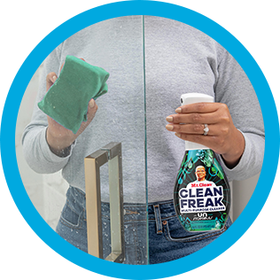 A person cleaning soup scum of shower glass with CleanFreak Unstopables