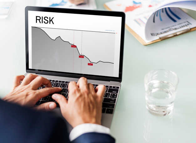 Man operating laptop with a graph notated as "risk"