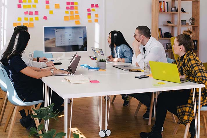 Team of 5 collaborating and sitting around table