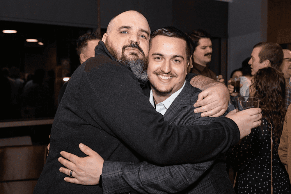 PowerShell Podcast hosts, Jordan Hammond and Andrew Pla embrace at PDQ Week 2023