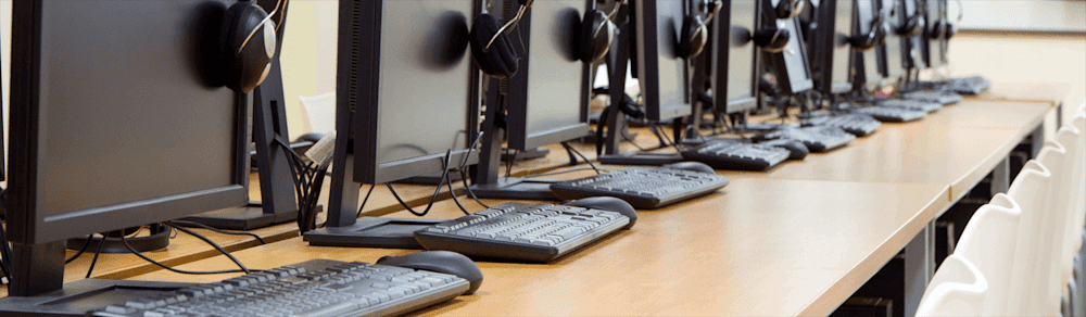 Row of computer lab PCs on desks