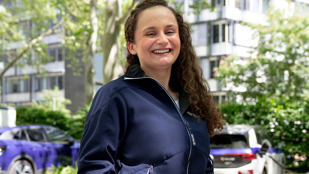 Lächelnde junge Frau in dunkelblauer Jacke.