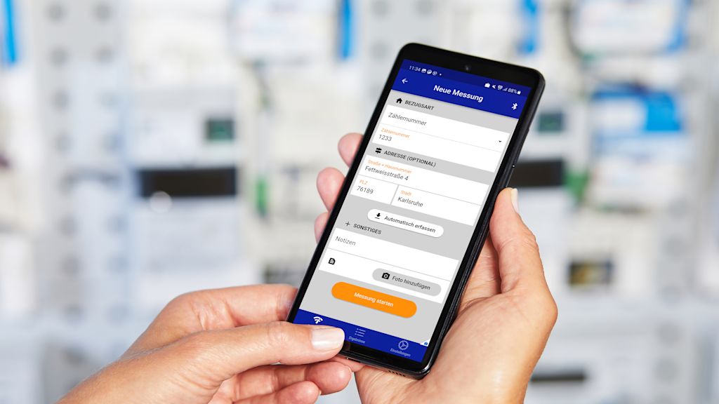 Zwei Hände halten ein Smartphone. Die Oberfläche der PegelMeter App ist zu sehen.