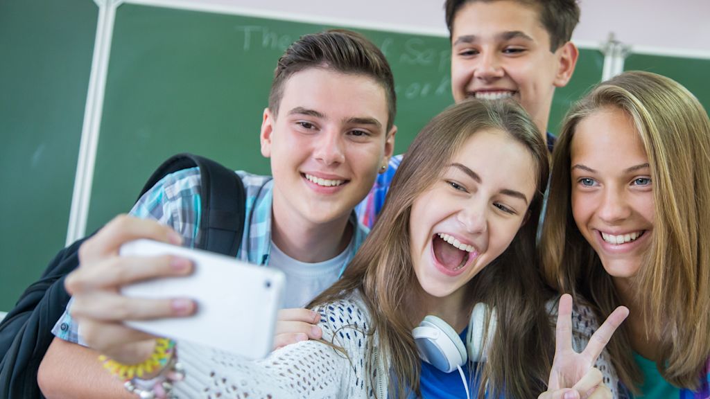 Vier Schulfreund*innen machen ein Selfie.