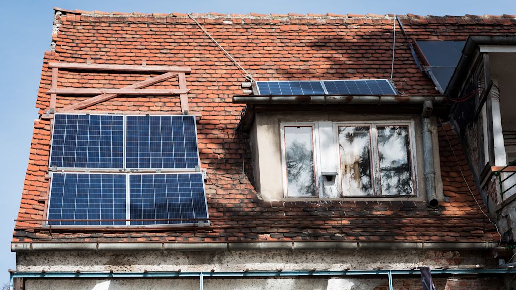 Dach mit Solarpanelen und alten Ziegeln.