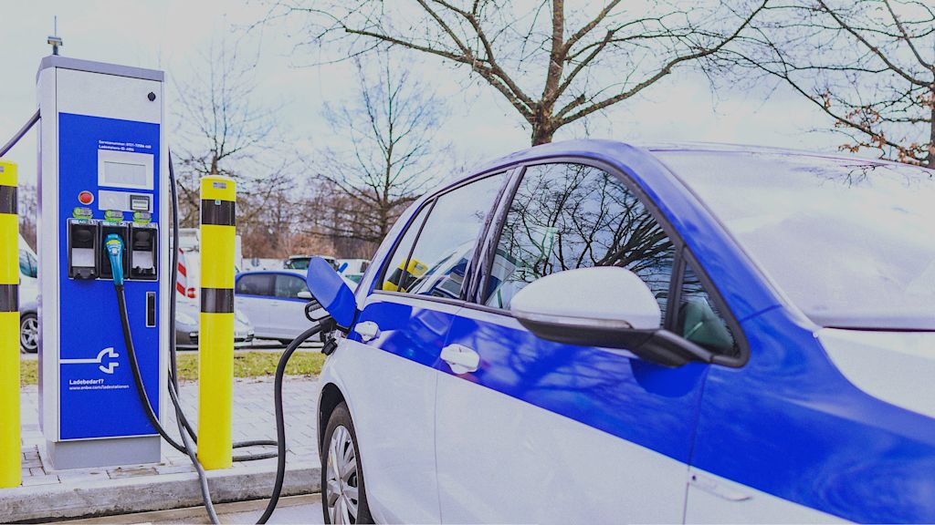 Blau-weißes Elektroauto am Ladepunkt.