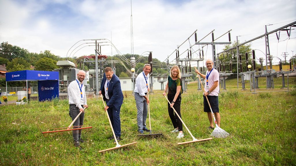 Rechen im „Summspannwerk“ das frische Mähgut zusammen (v.l.): Alexander Kozel (Bürgermeister von Knittlingen), Oliver Simonek (Geschäftsführer OEW Zweckverband Oberschwäbische Elektrizitätswerke), Steffen Ringwald (Netze BW-Geschäftsführer), Umweltministerin Thekla Walker und Lennart Jurjen Molenaar (Projektleiter, Netzwerk Blühende Landschaft) (Foto: Netze BW)