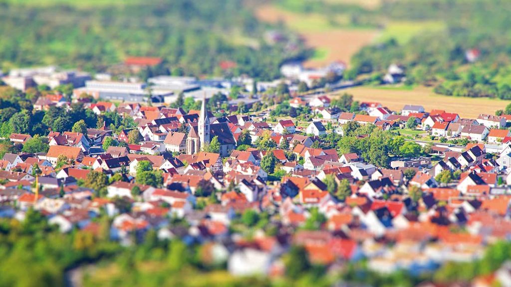Luftbild eines Dorfes mit Kirche in der Mitte.